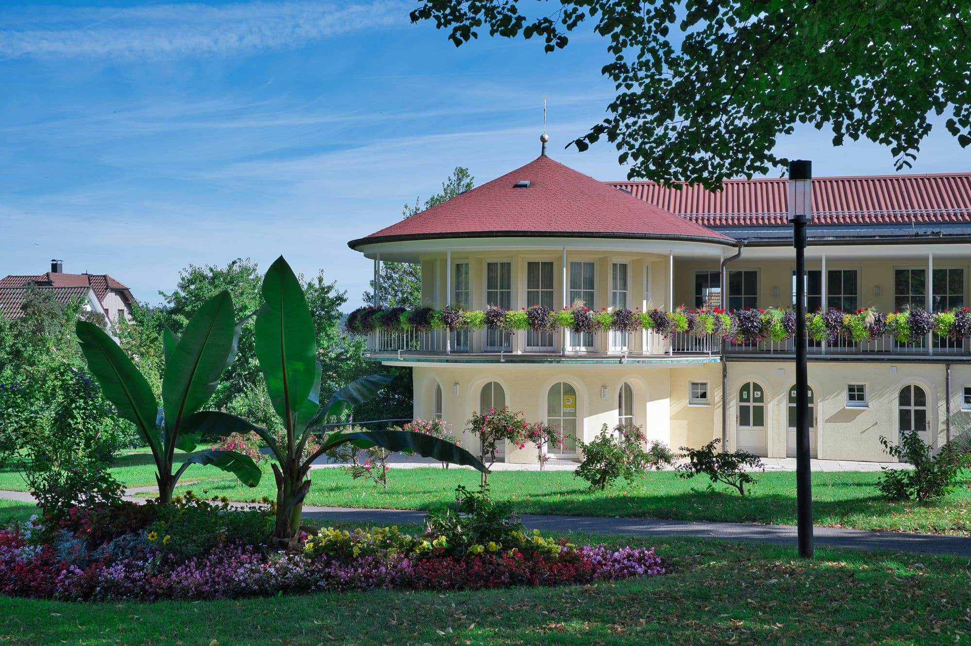 Gepflegtes Wohngebäude mit Balkonblumen und angelegtem Garten